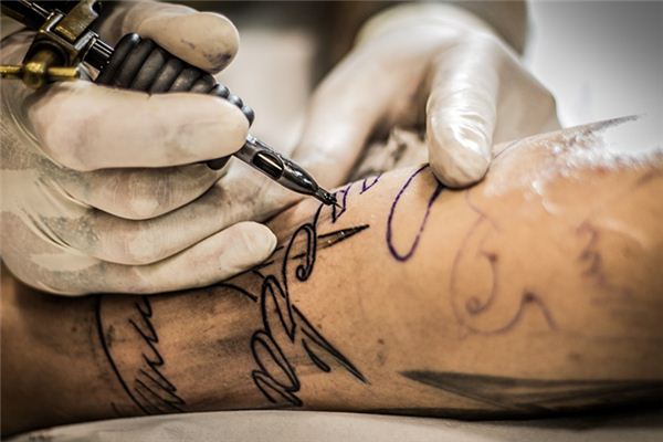 What does it mean to dream about someone else getting a tattoo?
